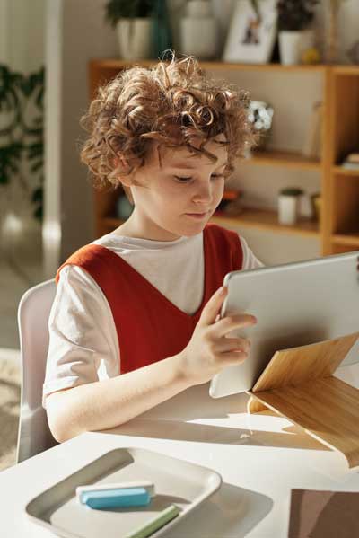a child looking at a computer tablet